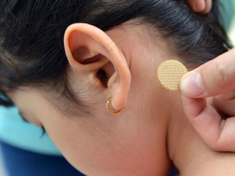 Dùng miếng dán chống say xe sau tai